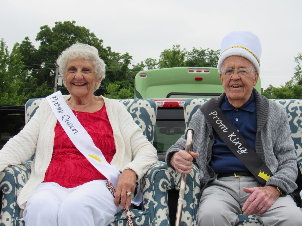 Couple sitting in Parade as Prom King and Queen