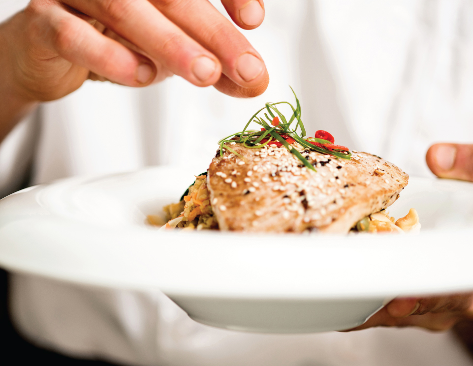 chef seasoning a dish